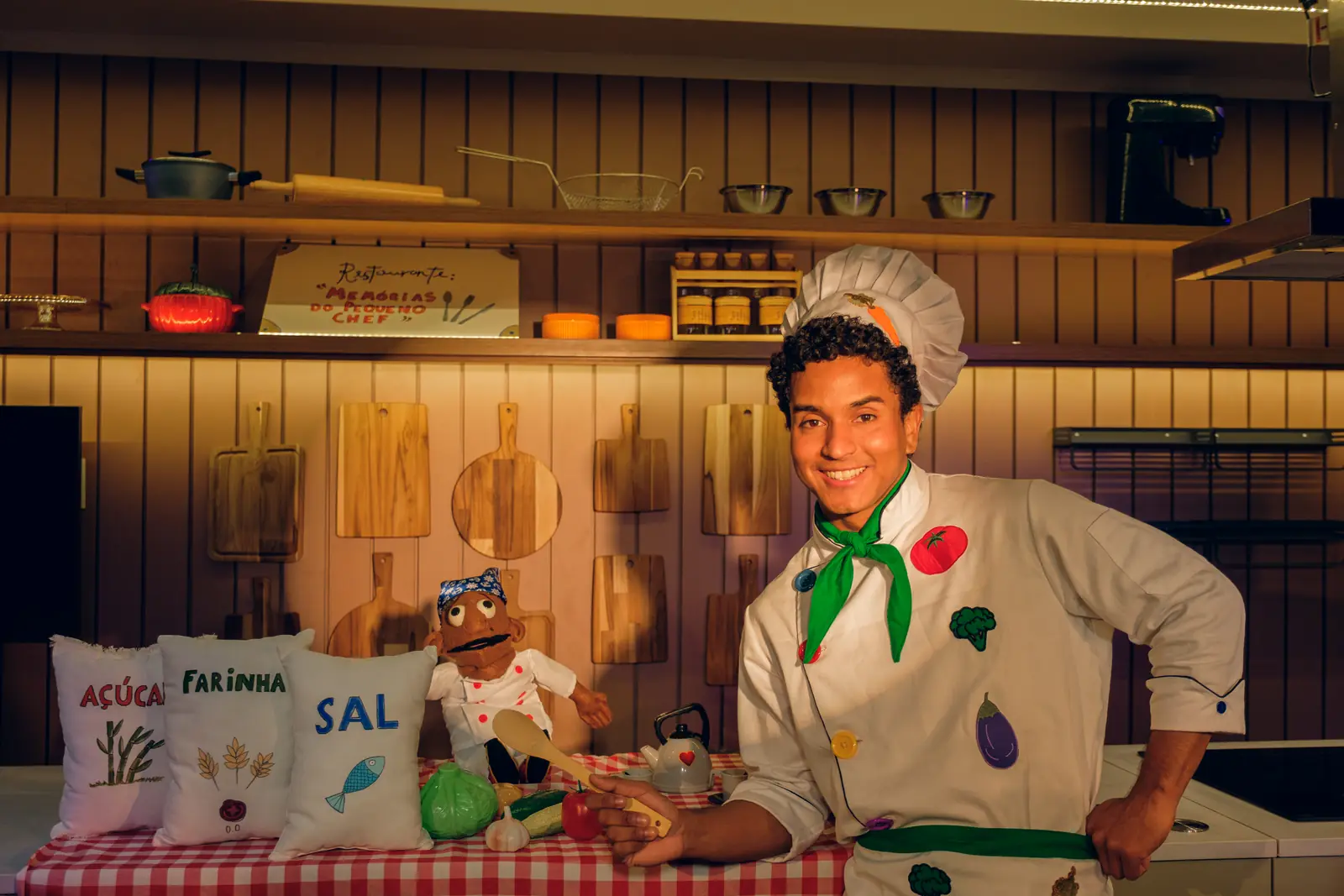 Jean Marques, como João, sorrindo na cozinha do cenário.
